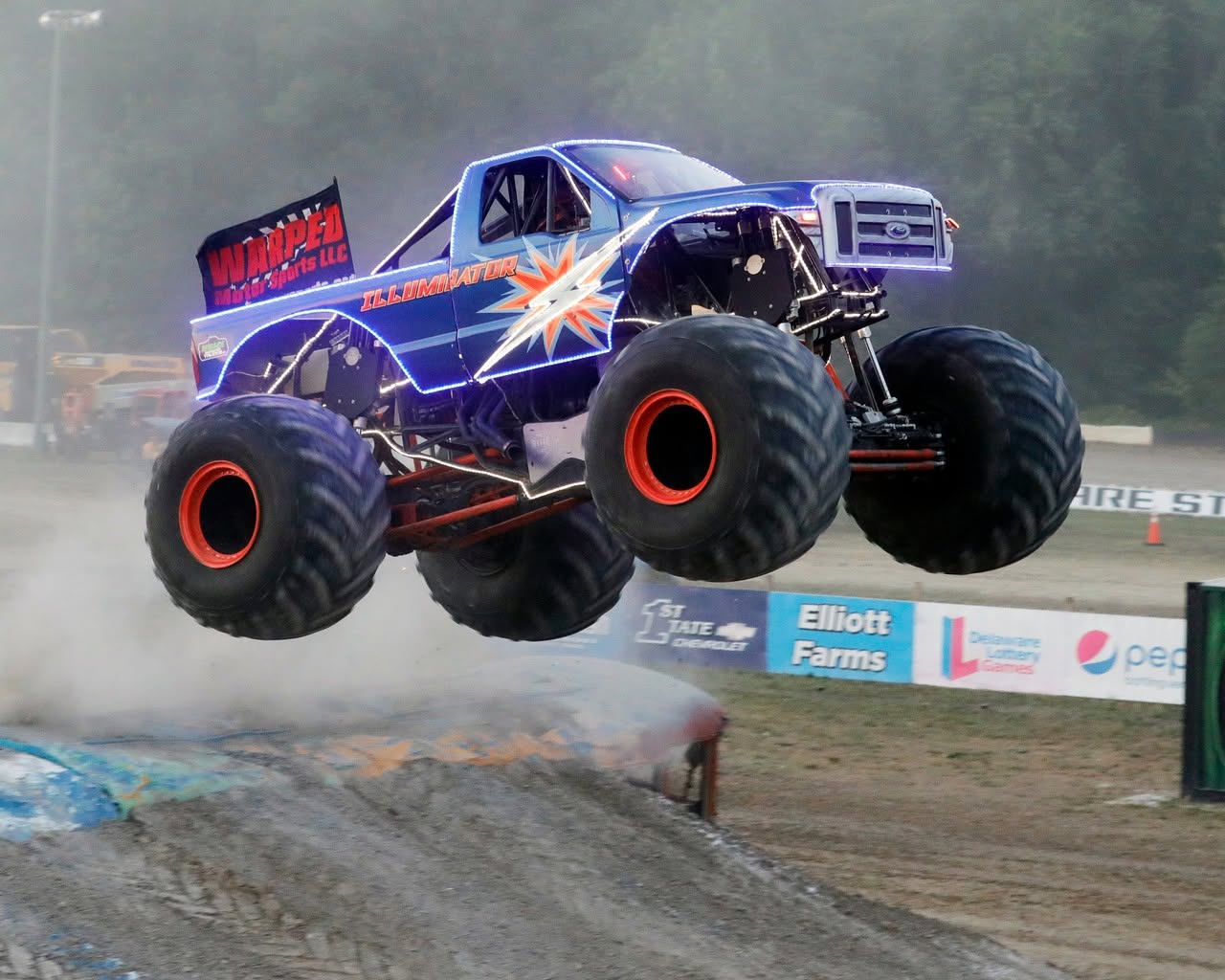 Illuminator Monster Truck jumping over a school bus during the freestyle competition at Delaware International Speedway in Delmar, DE, USA