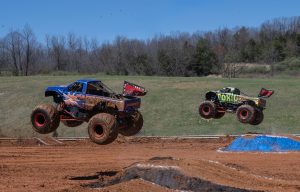 The Illuminator Monster Truck and Toxic Monster Truck facing off in a head-to-head drag race during the racing competition