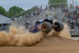 The Illuminator Monster Truck emerging from a thick cloud of dust leaving the starting line during the head-to-head racing competition in Gaithersburg, Maryland, USA
