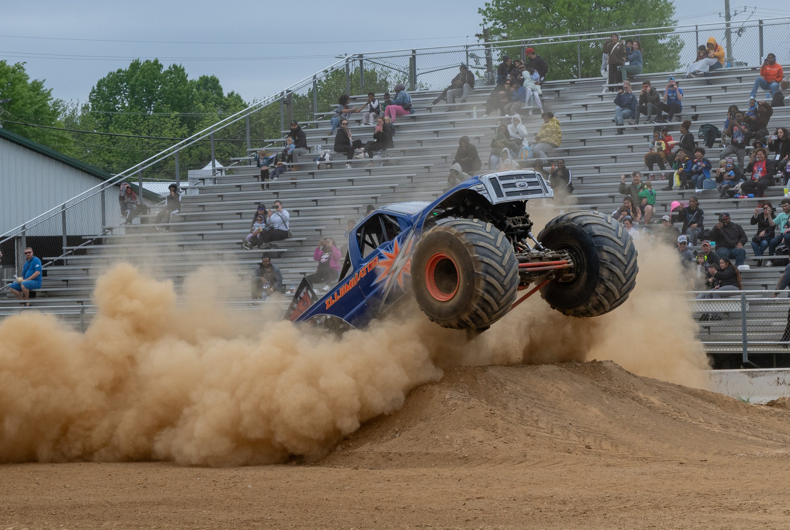 The Illuminator Monster Truck emerging from a thick cloud of dust leaving the starting line during the head-to-head racing competition in Gaithersburg, Maryland, USA
