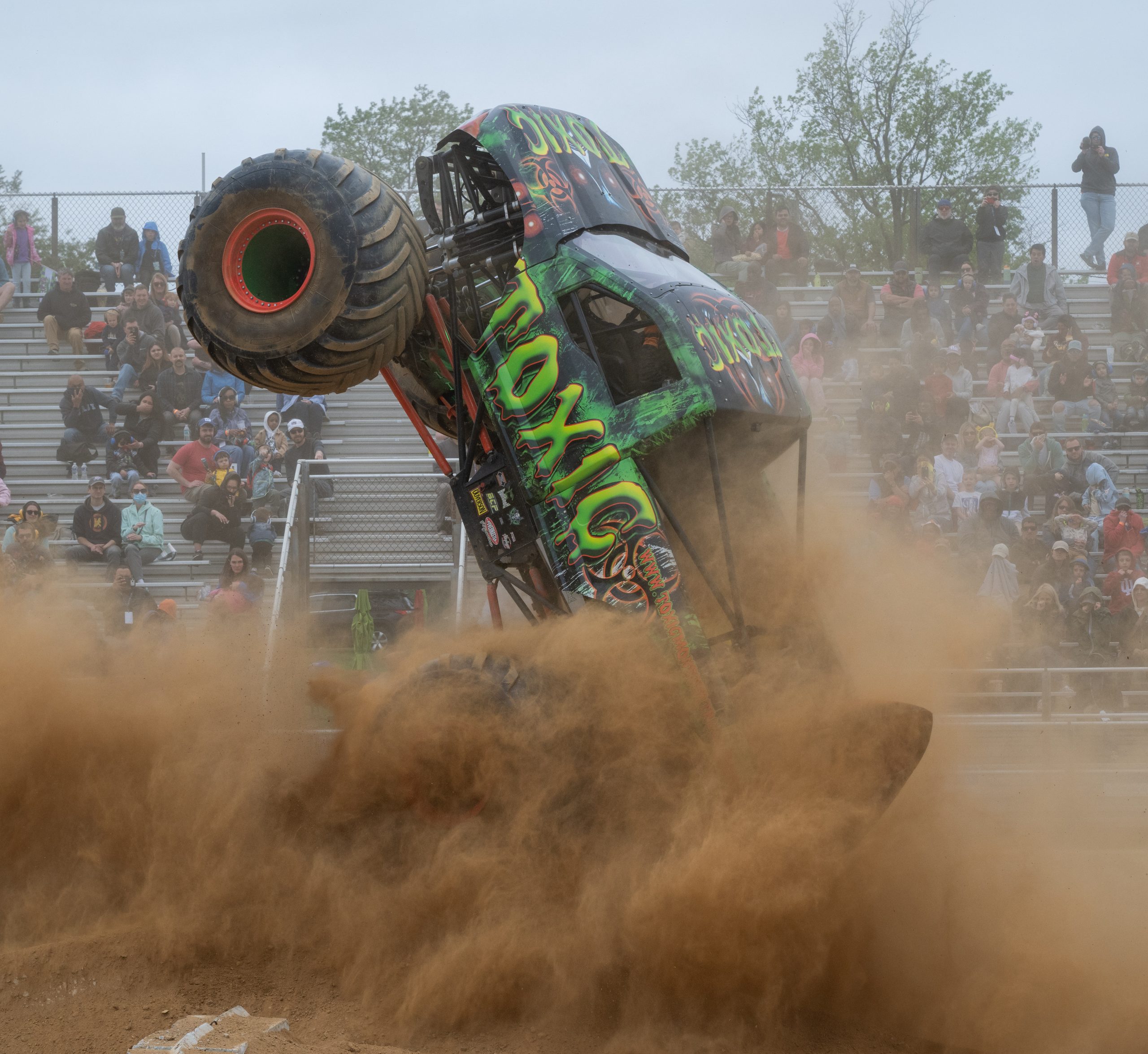 The Toxic Monster Truck executing a picture perfect sky wheelie through the thick dust at the Montgomery County Agricultural Fairgrounds in Gaithersburg, Maryland, USA during the freestyle competition